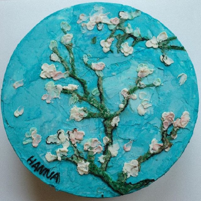 Pastel de la repostera Koike, de fondo azul y árbol de cerezo con flores blancas