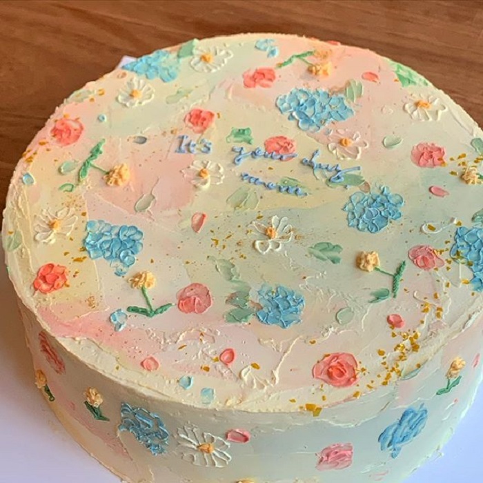 Pastel de la repostera Koike, en colores pastel, fondo beige, detalles azules, rosas y amarillos