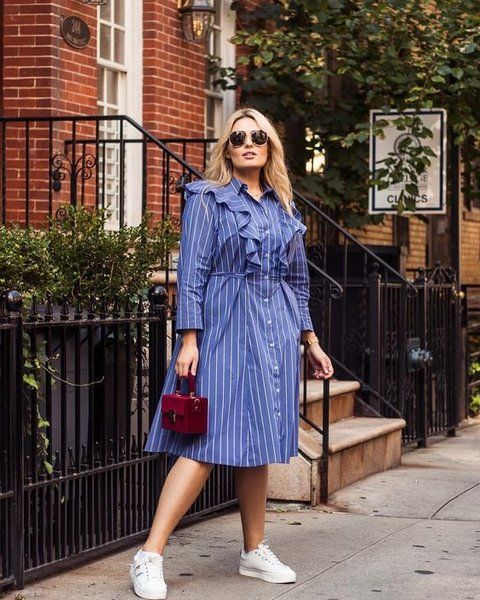 Chica plus size con vestido azul de botones y holanes al frente