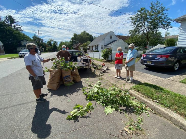 Brian Schwartz recogiendo ramas después de un trabajo de jardinería