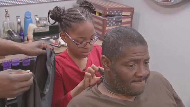 Neijae Graham-Henries cortándole el cabello a un hombre de escasos recursos