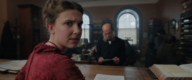 Escena de la película Enola Holmes, en la que aparece Enola mirando hacia la cámara