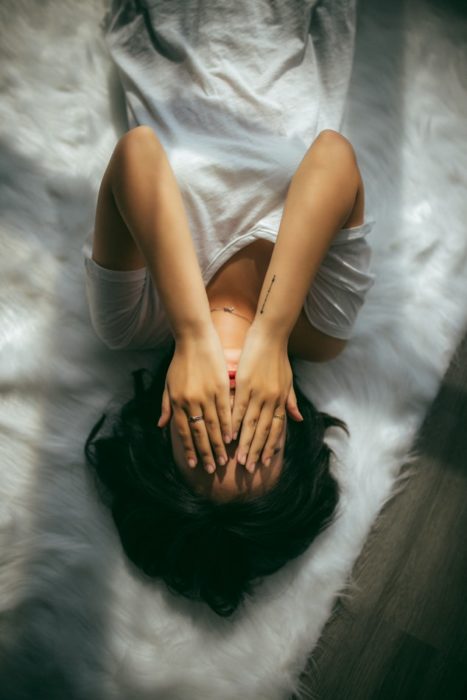 Chica sobre la cama triste