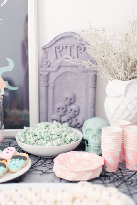 Mesa de dulces para Halloween en tonos pastel con palomitas de maíz de color verde