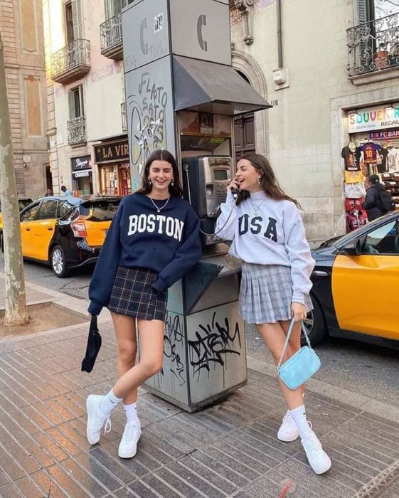 Chicas usando falda a cuadros y sudaderas holgadas