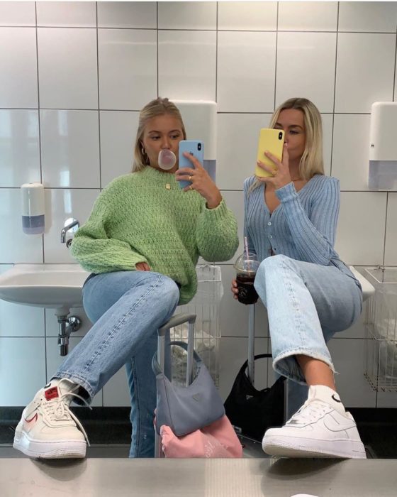 Chicas usando mom jeans y suéteres holgados en verde y azul pastel