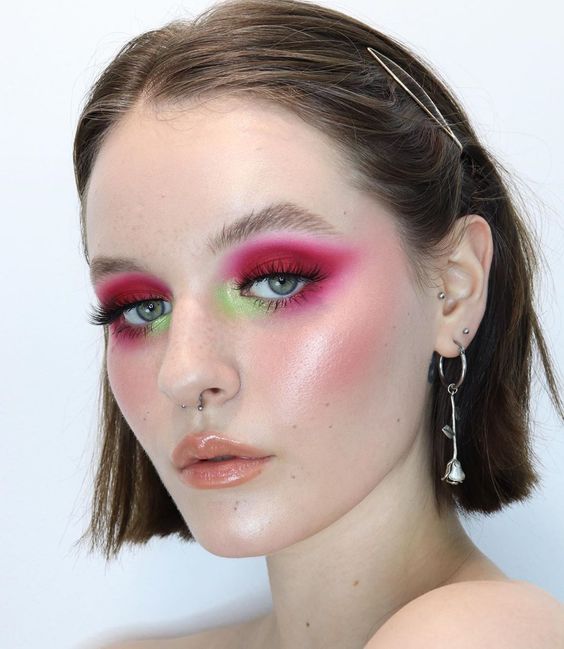 Chica blanca con cabello corto y maquillaje en rosa y verde