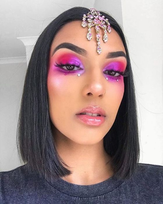 Chica morena clara con cabello lacio corto y maquillaje colorido