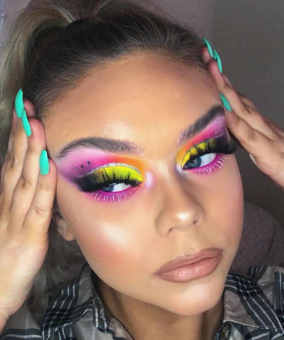 Chica morena con maquillaje de ojos en rosa, amarillo y morado
