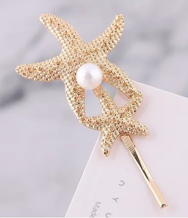 Pasador en forma de estrella de mar con una perla blanca