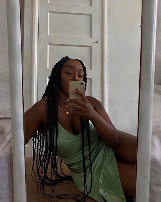 chica morena curvy con cabello oscuro largo usando un vestido de satén verde