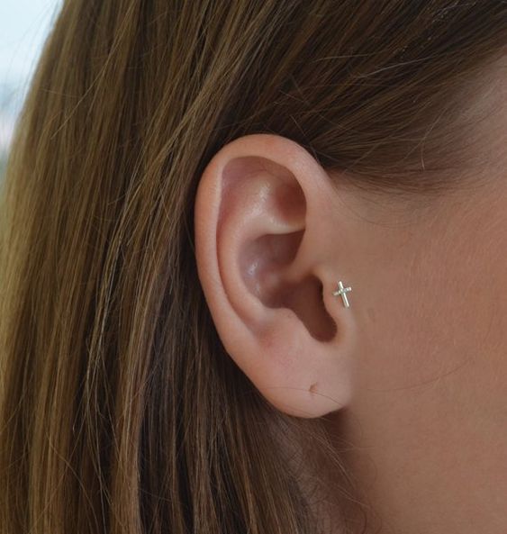 Tragus piercing de cruz