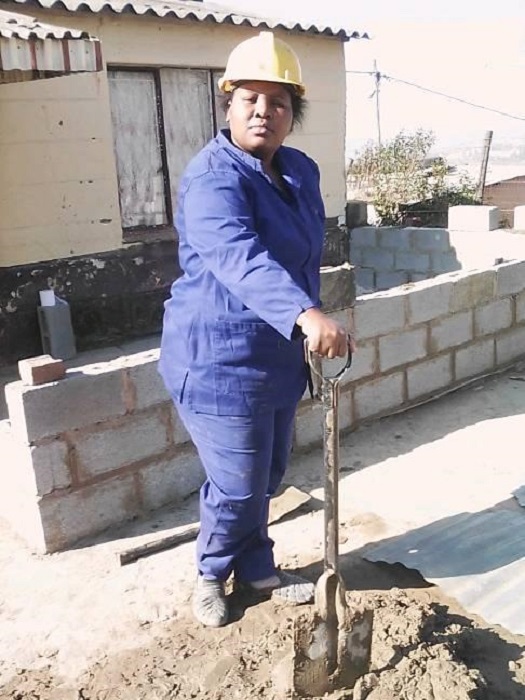 Zamanzini Philisiwe preparando mezcla para continuar construyendo