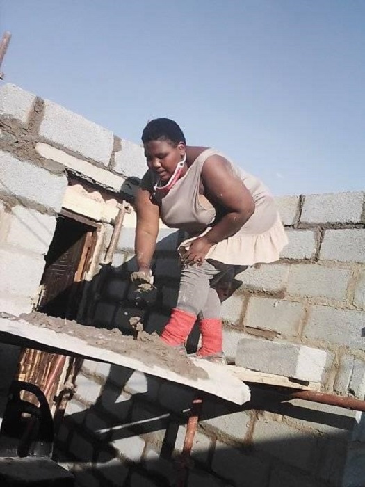 Zamanzini Philisiwe construyendo su casa