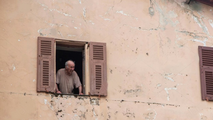 señor en italia viendo por la ventana imagen de stock