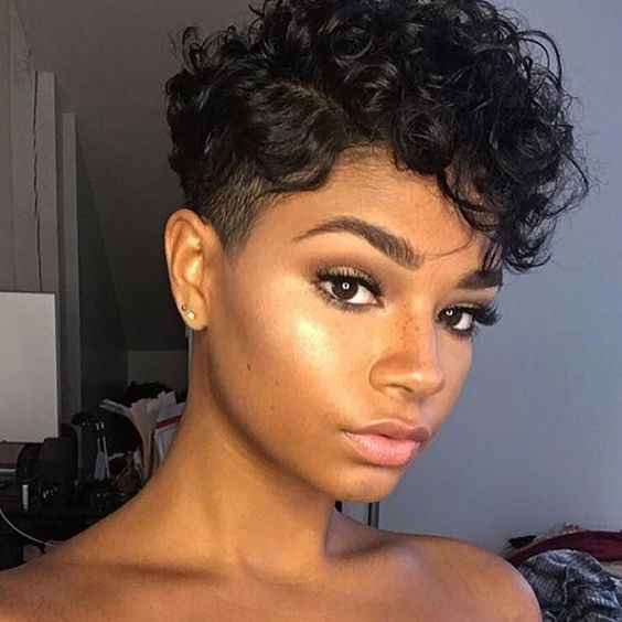 Chica morena con cabello rizado corto estilo pixie
