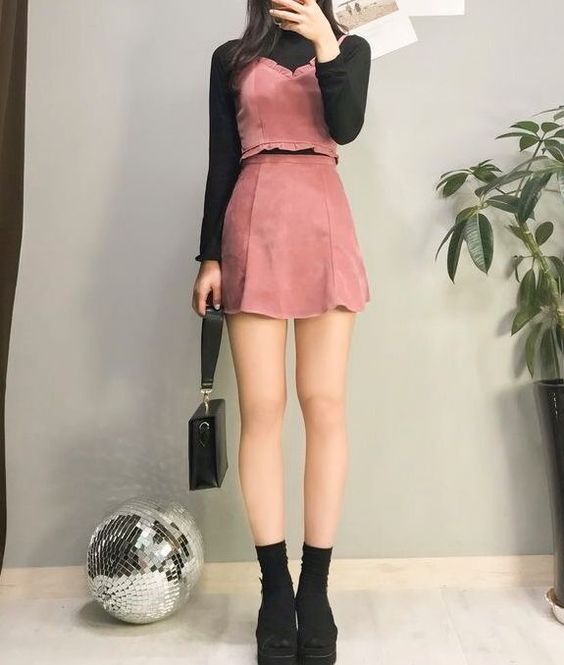 Chica tomándose selfie con blusa negra de cuello alto con vestido rojo y calzando negro