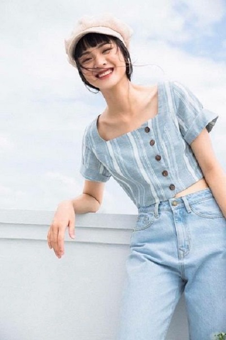 Chica usando mom jeans y blusa de botones azul cielo de botones laterales
