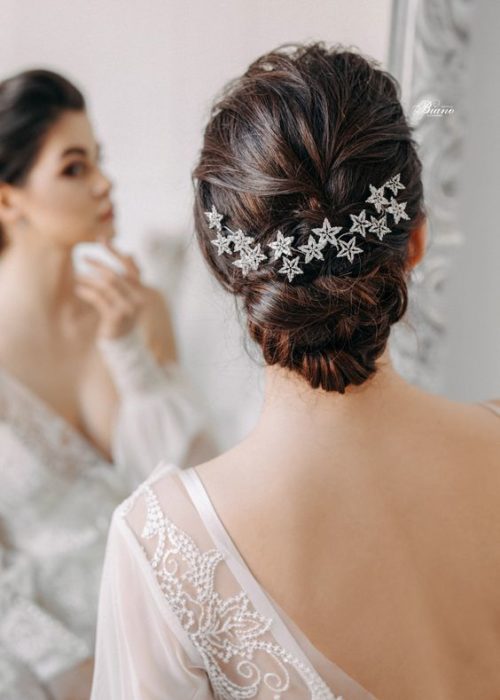 Chica de cabello oscuro recogido en un chongo con broches de estrella