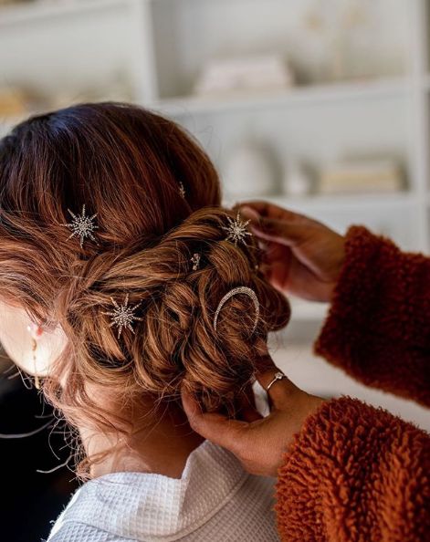 Novia pelirroja con recogido bajo y broches pequeños en forma de estrellas