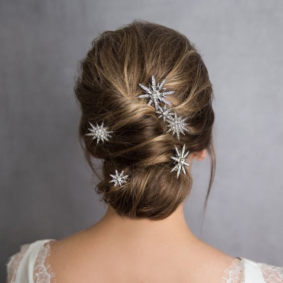 Chica rubia con chongo bajo y accesorios de cabello en forma de estrellas