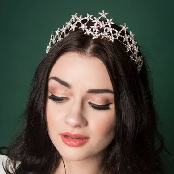 Chica con cabello suelto castaño oscuro con diadema de estrellas 