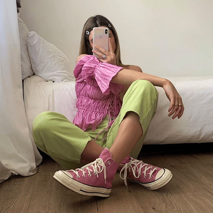 chica usando blusa rosa, pantalón color pistache y converse rosas