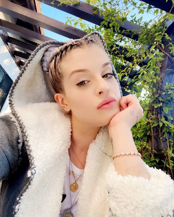 Kelly Osbourne con trenzas holandesas, usando una sudadera y maquillaje suave
