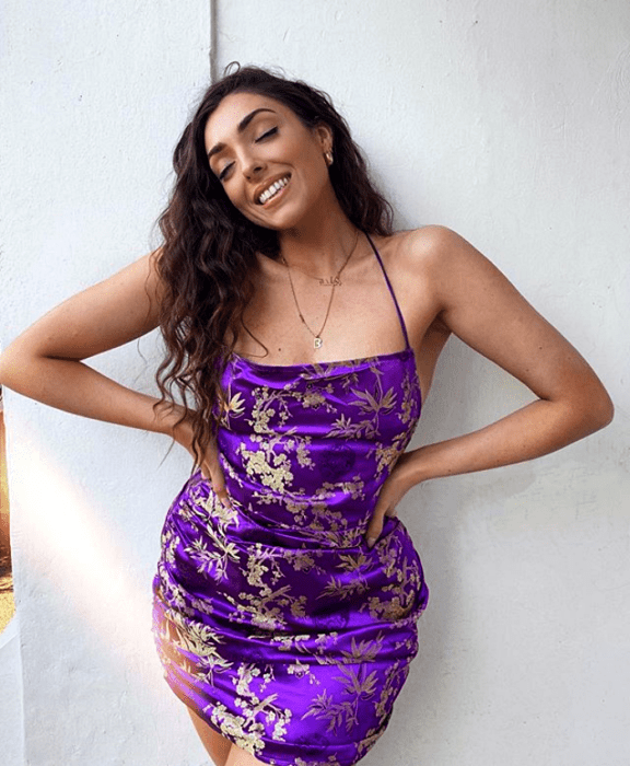Chica morena en un vestido morado brillante ceñido con tirantes