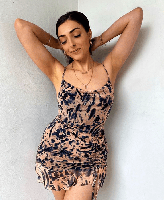 Chica en un vestido ceñido de color nude con estampado azul