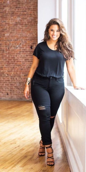 Chica usando un total black look de jeans rasgados, blusa de manga corta y tacones