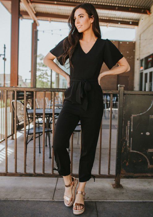 Chica usando un total black look de jumpsuit y sandalias