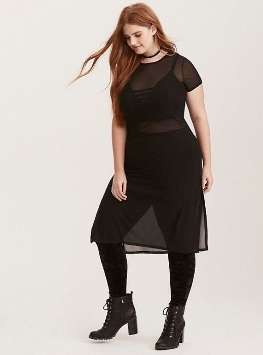 Chica usando un total black look de unos leggins y blusón de transparencia y botines