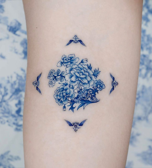 Tatuaje pequeño estilo japonés de tinta azul, flores y ave