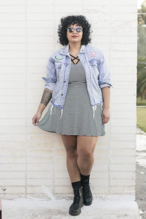 Chica plus size con vestido de rayas blancas y negras y chamarra de mezclilla
