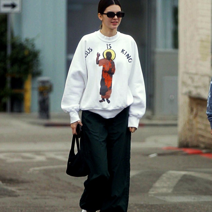 Kendall Jenner con una sudadera blanca oversized y pantalones deportivos verde militar
