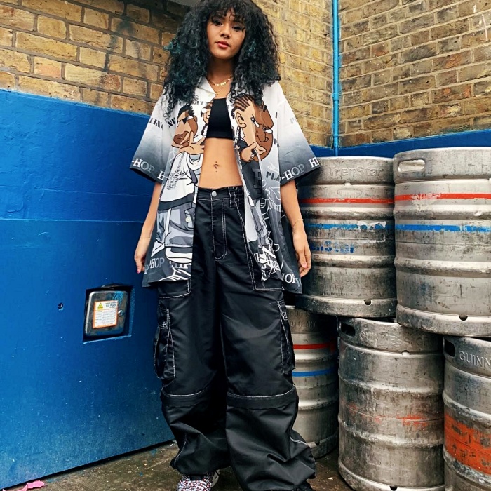 Chica con una camisa oversized estampada y pantalones cargo azul marino