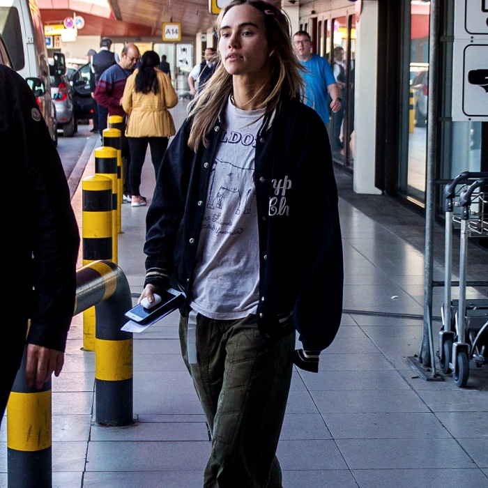 Chica con camiseta gris y chaqueta bomber azul marino