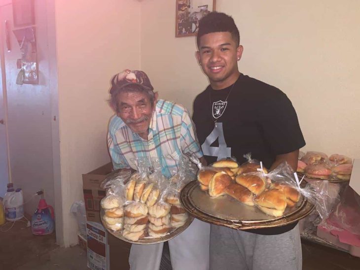 Chico ayudando a un adulto mayor a vender pan a través de redes sociales 