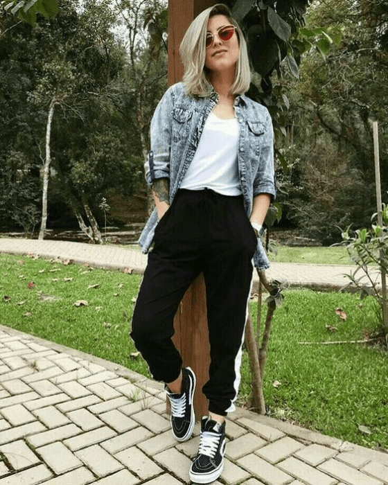Chica usando pantalones negros, blusa blanca y una camisa denim