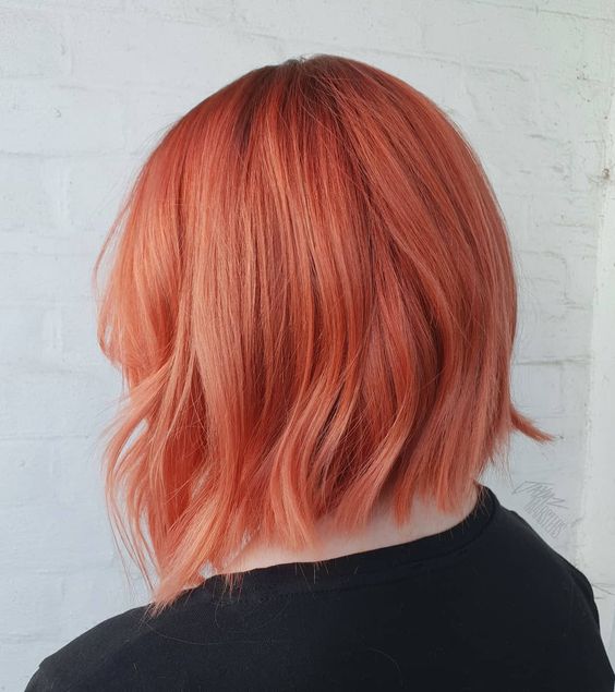 Chica de espaldas mostrando su melena corta teñida con tinte peachy copper
