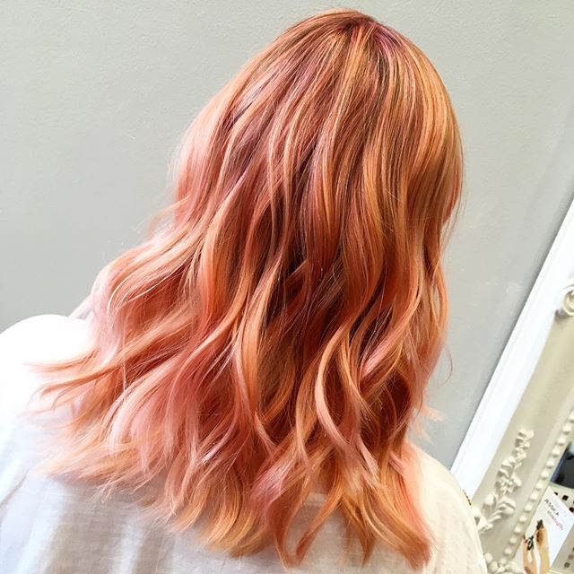 Chica de espaldas mostrando su cabello largo teñido en estilo peachy copper