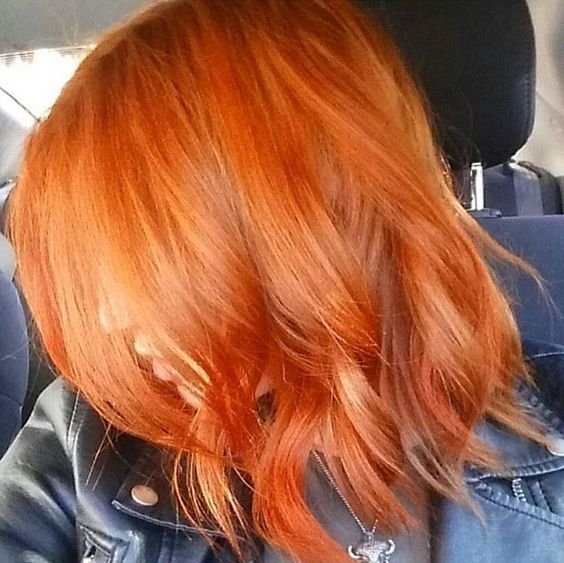 Chica de perfil enseñando su cabello teñido en efecto peachy copper