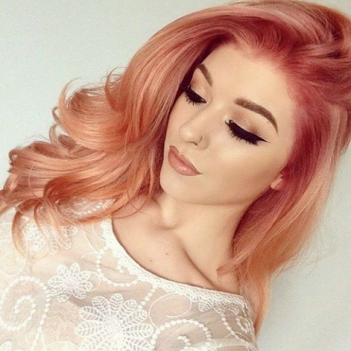 Chica yendo hacia abajo mostrando su cabello teñido en efecto peachy copper