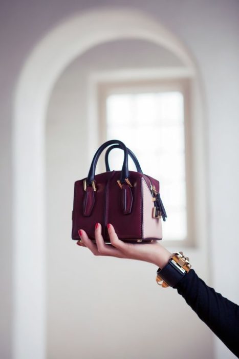 Bolso de mano pequeño color vino con asas color negro estilo maletín
