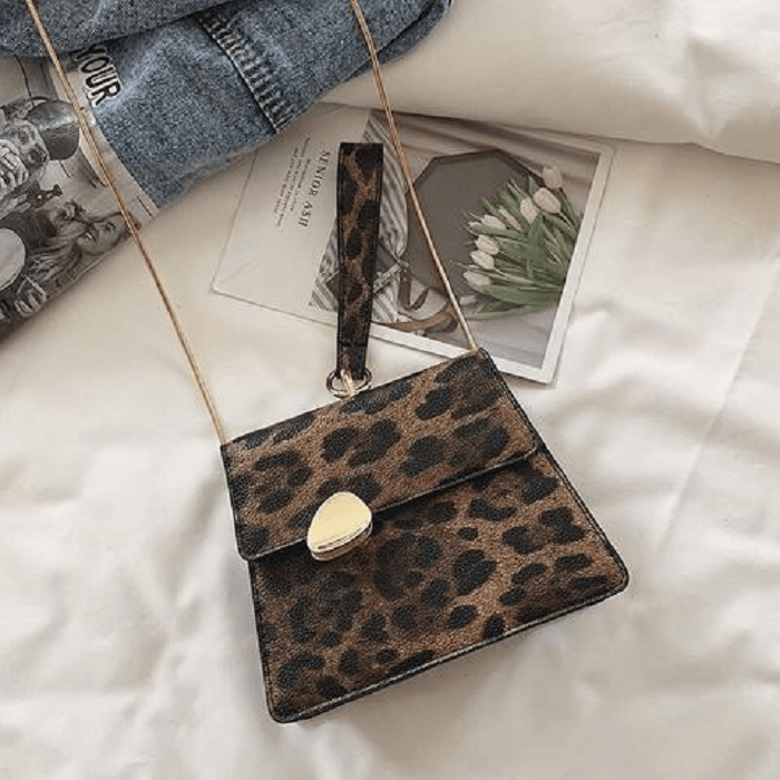 Bolso de mano pequeño de estampado animal print y correa de cadena color dorado