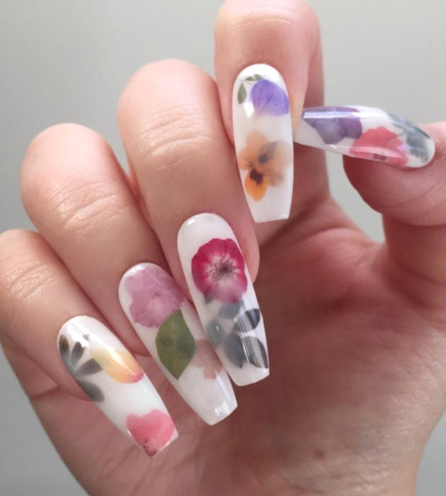 Diseños de manicura milk bath; uñas largas cuadradas, blancas con flores rosas, rojas, anaranjadas y moradas con hojas verdes