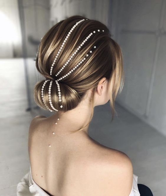 Mujer rubia con recogido bajo con perlas