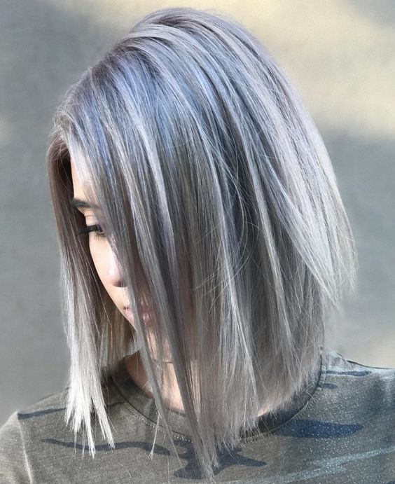 Chica con el rostro agachado mostrando su cabello teñido con silver highlights