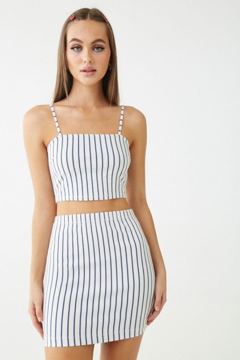Chica usando mini falda y top a juego, color blanco con líneas negras